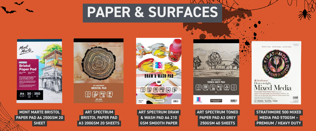 Smooth hot press and bristol paper pads displayed with pen and ink drawings, ideal surfaces for inking during Inktober.