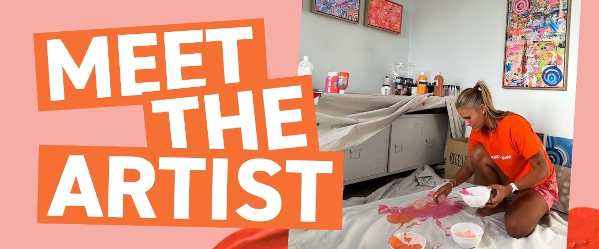 Bayley Mifsud kneeling on a drop sheet mixing pink and orange paint in her studio